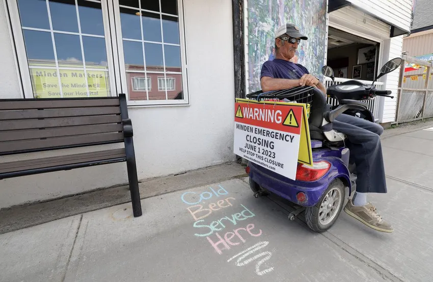 Signs urging the saving of the hospital emergency department are found at many businesses, homes, and Doug Alton's scooter.